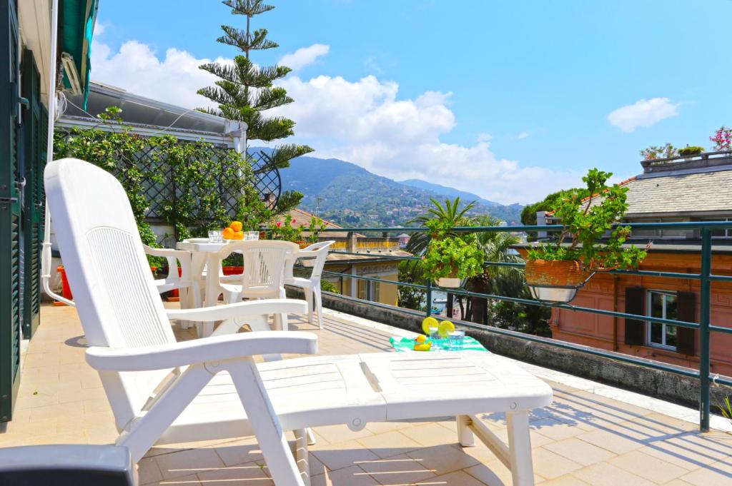 eine Gruppe weißer Stühle auf einem Balkon in der Unterkunft Colombo Flexyrent Studio in Rapallo