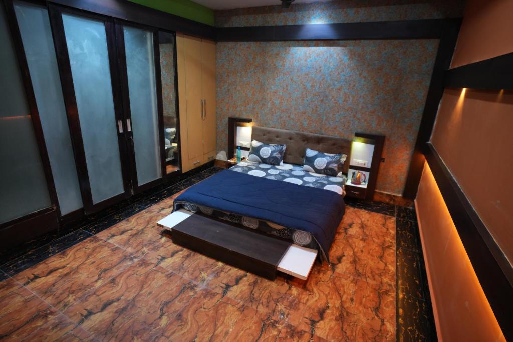 a bedroom with a blue bed and large windows at Hotel Konaaz Inn in Alīgarh