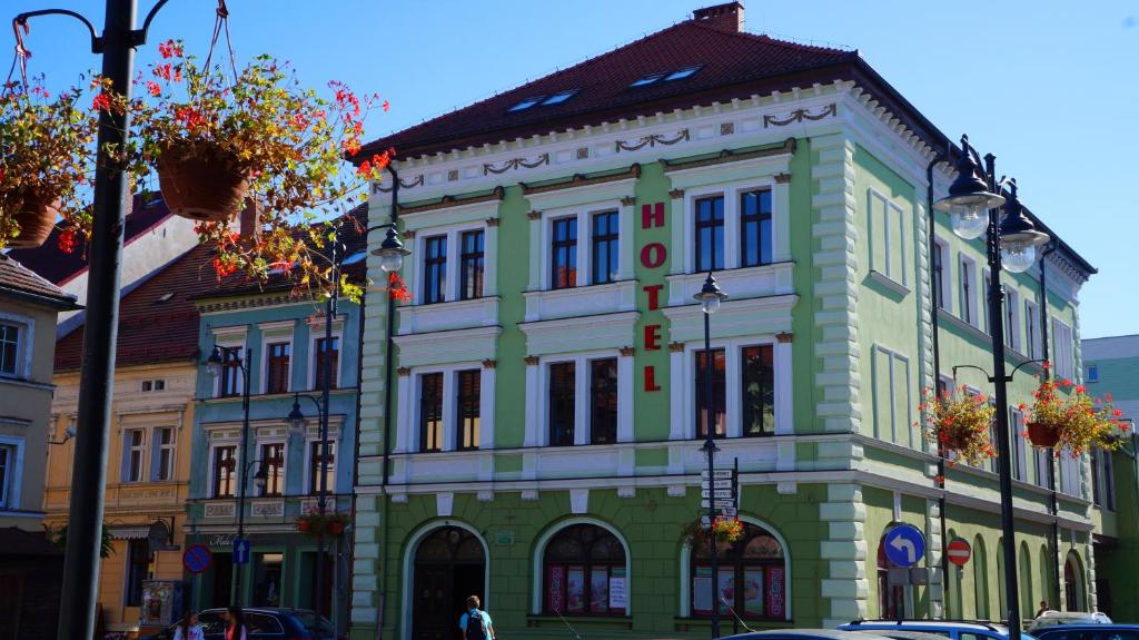 zielony i biały budynek przy ulicy miejskiej w obiekcie Hotel Leliwa w mieście Leśna