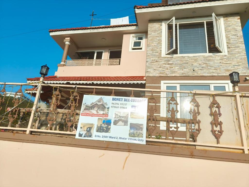 a balcony of a house with a sign on it at Honey Bee Cottages in Ooty