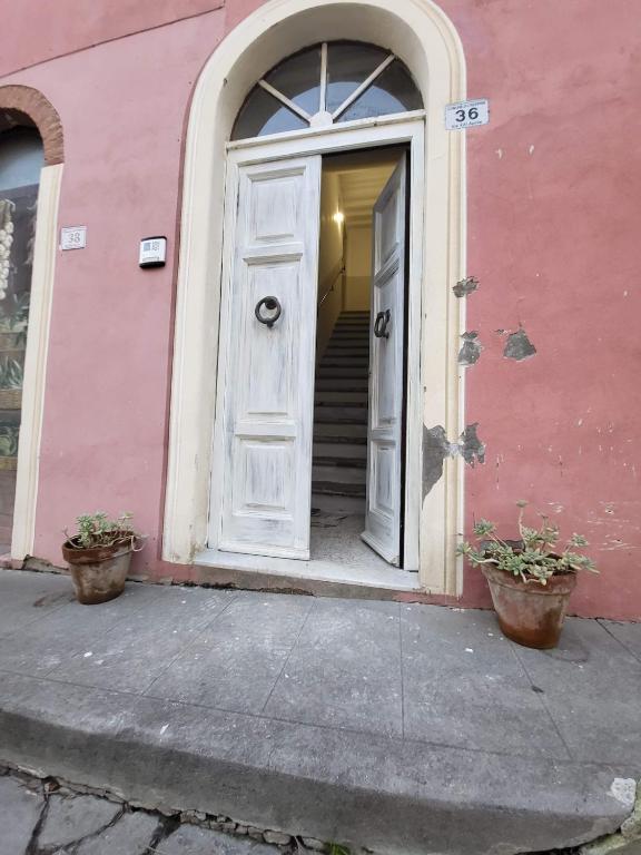 an entrance to a pink building with a white door at Dimora Rosé in Crespina