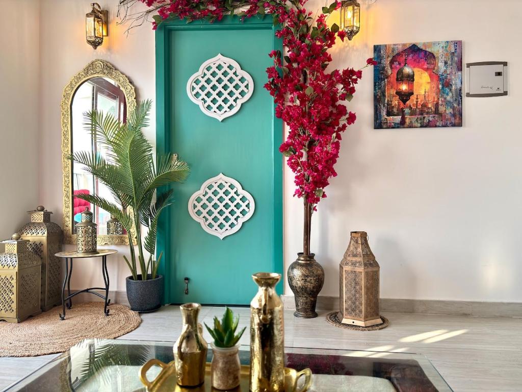 a room with a turquoise door and flowers on the wall at Royal Moroccan Escape in Noida in Noida
