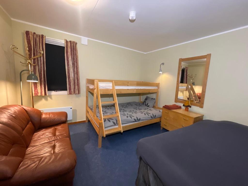 a bedroom with a bunk bed and a couch at Laplanders room 3 in Kiruna