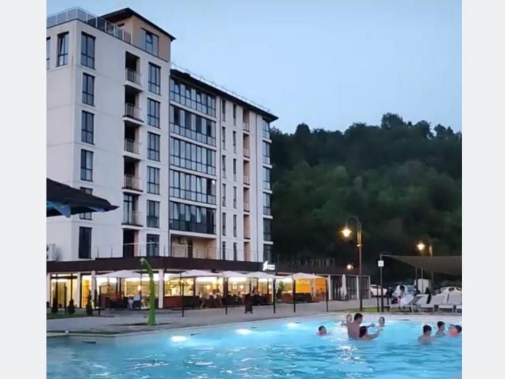a group of people in a swimming pool next to a building at Апартаменты Сонячний квартал in Golubinoye