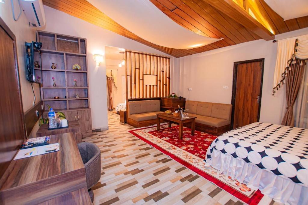 a bedroom with a bed and a living room at RJ Hotel Pokhara in Pokhara