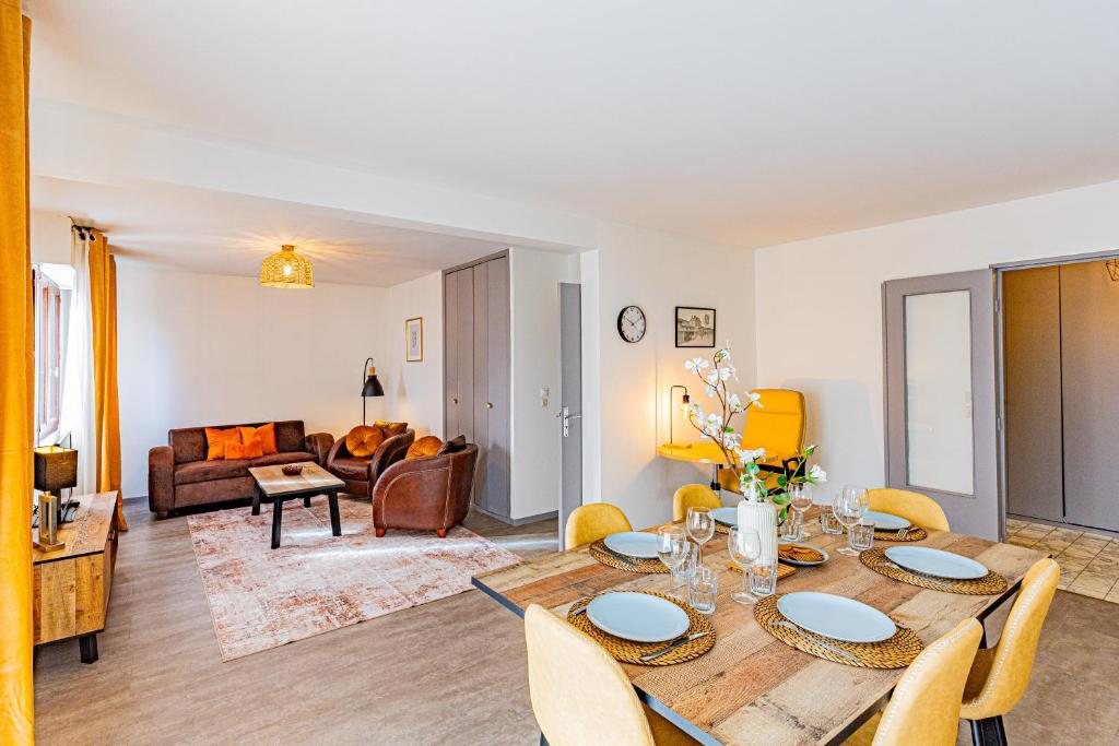 a living room with a table and chairs and a couch at Le 28 C chouette - Spacieux - Box privé - Ascenseur - Centre in Dijon