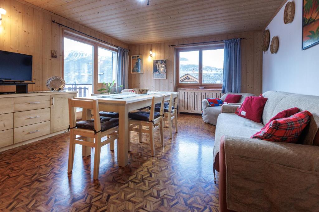 a living room with a table and a couch at Chalet Beppe in Bormio