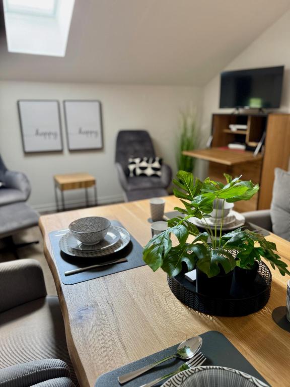 ein Wohnzimmer mit einem Tisch, auf dem eine Pflanze steht in der Unterkunft Apartment Oberdeck für 4 Personen, Wifi, Parkplätze uvm in Brokstedt