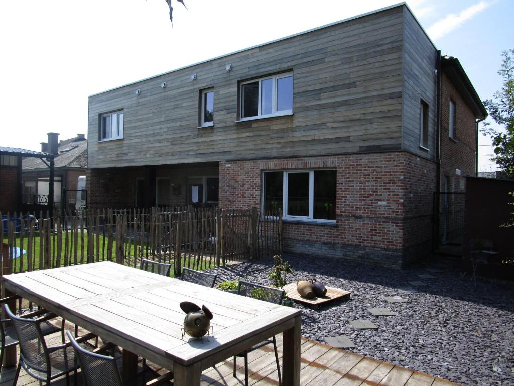 a house with a wooden table in front of it at B&B Wiezebed in Wieze