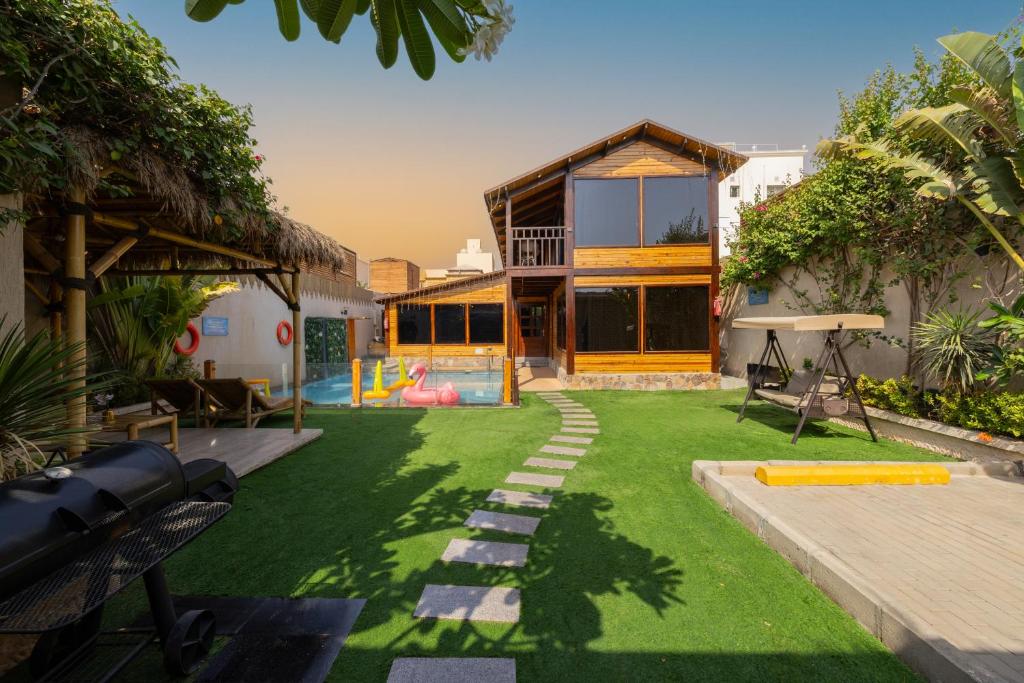 a house with a yard with a pool at اكواخ لوسو الريفيه in Ḩayy al Ḩamdānīyah