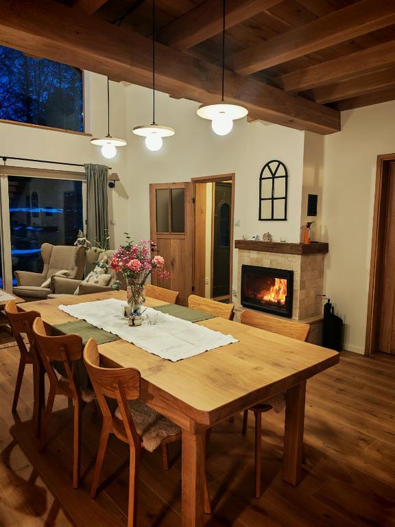 a living room with a wooden table and a fireplace at Słonna Chatka in Wujskie
