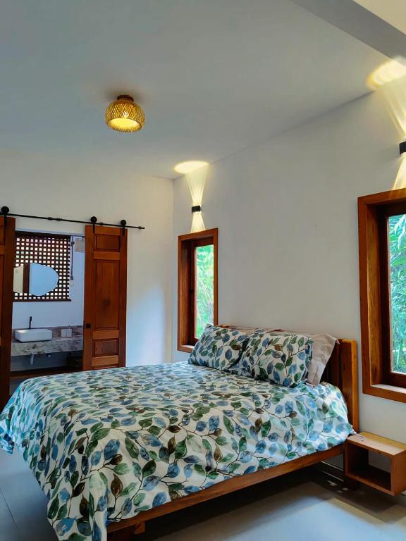a bedroom with a bed and two windows at Casa Miava - Studio 1 - Cozy place a few meters from the beach in Marau