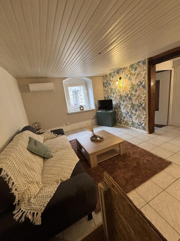 a living room with a bed and a table at Calm guest house in Clerval