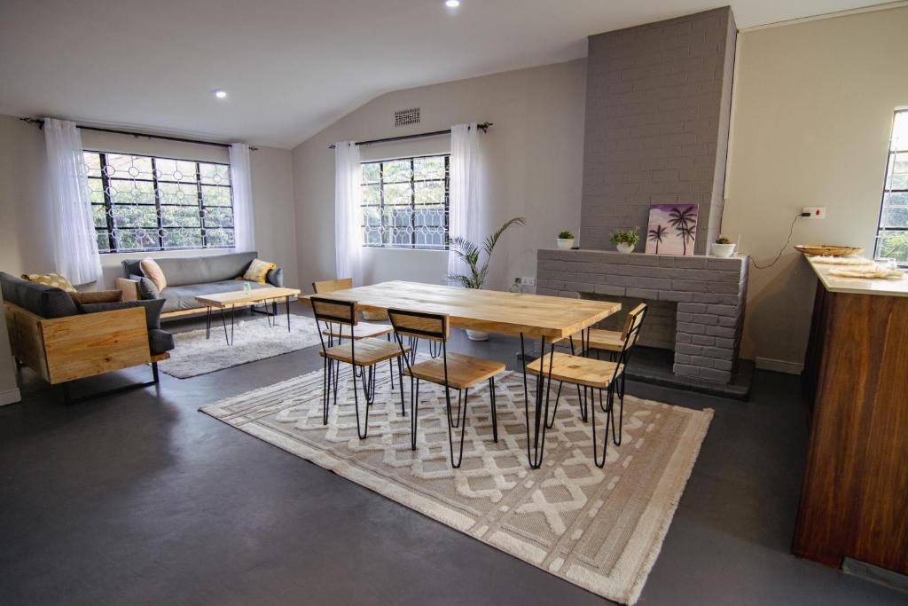 a living room with a wooden table and chairs at Open Gate House in Arusha