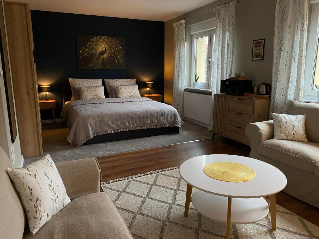 a bedroom with a bed and a couch and a table at Przy Jeziorze in Złotów
