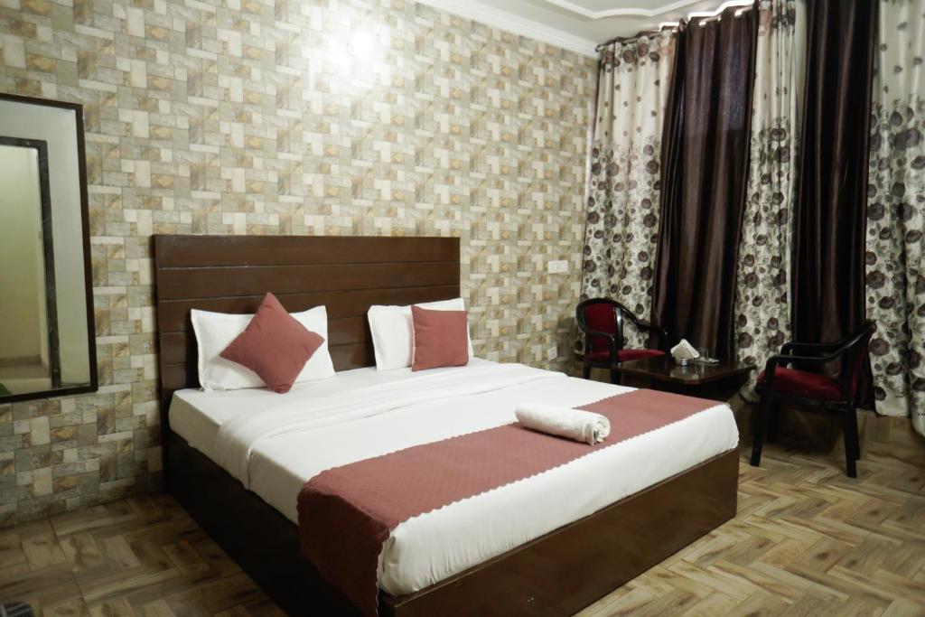 a bedroom with a large bed with red pillows at Hotel Majestica 22 in Chandīgarh