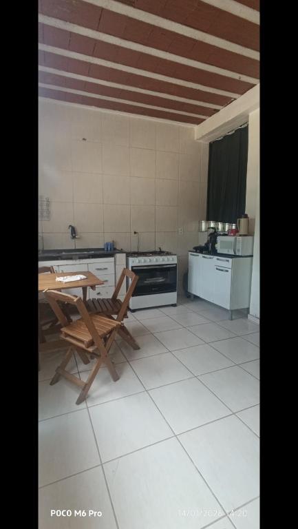 a kitchen with a table and chairs in a room at Casa 02 Cantinho e Sossego in Vespasiano