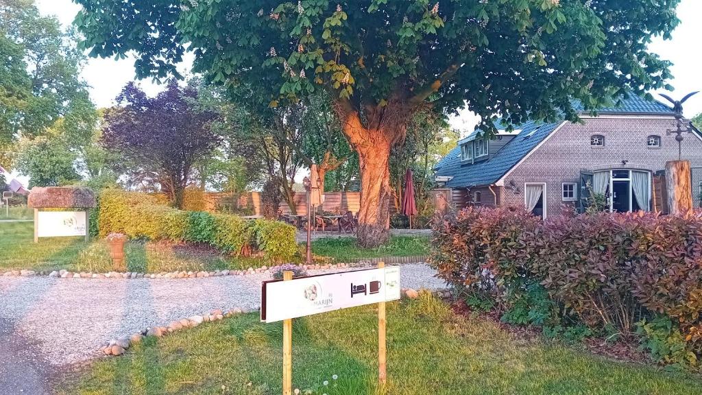 a sign in the grass next to a house at Bij Aquamarijn in Stieltjeskanaal