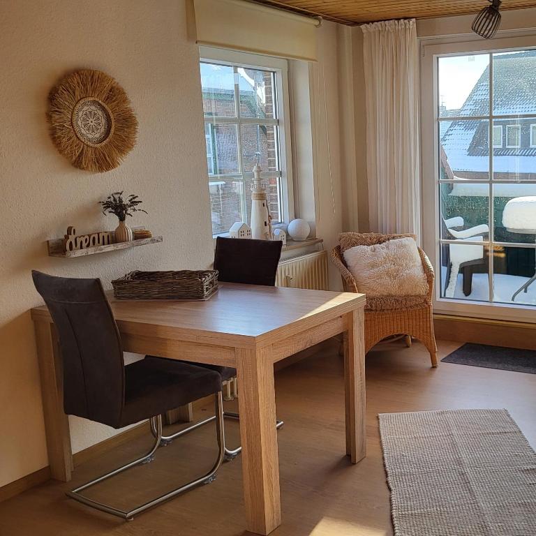 a dining room with a wooden table and chairs at lüttje Meerzeithuus in Carolinensiel