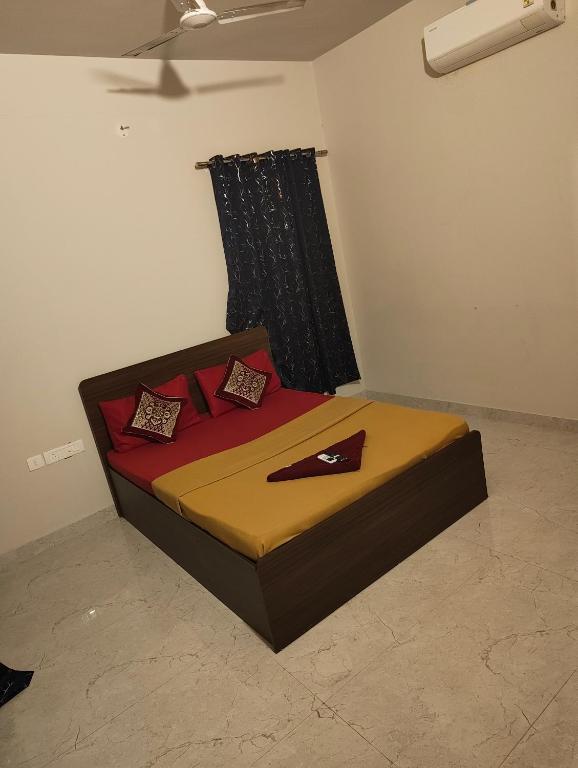 a bedroom with a bed with red and brown sheets at Two Heart heaven in Covelong