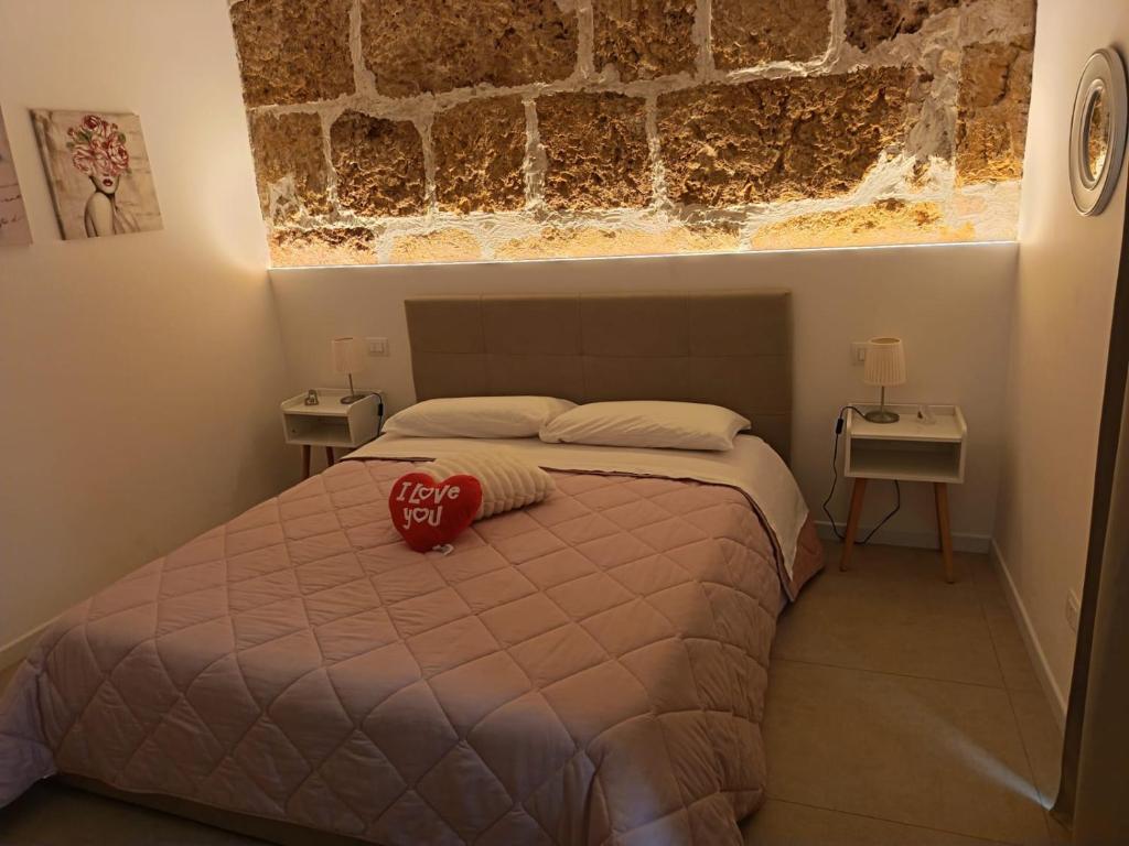 ein Schlafzimmer mit einem Bett, auf dem ein roter Hut liegt in der Unterkunft Holiday Home MATT ROS in Noto
