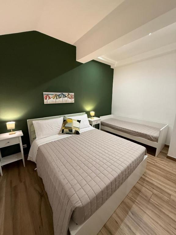 a bedroom with two beds and a green wall at Titti's Nest in Casteldaccia