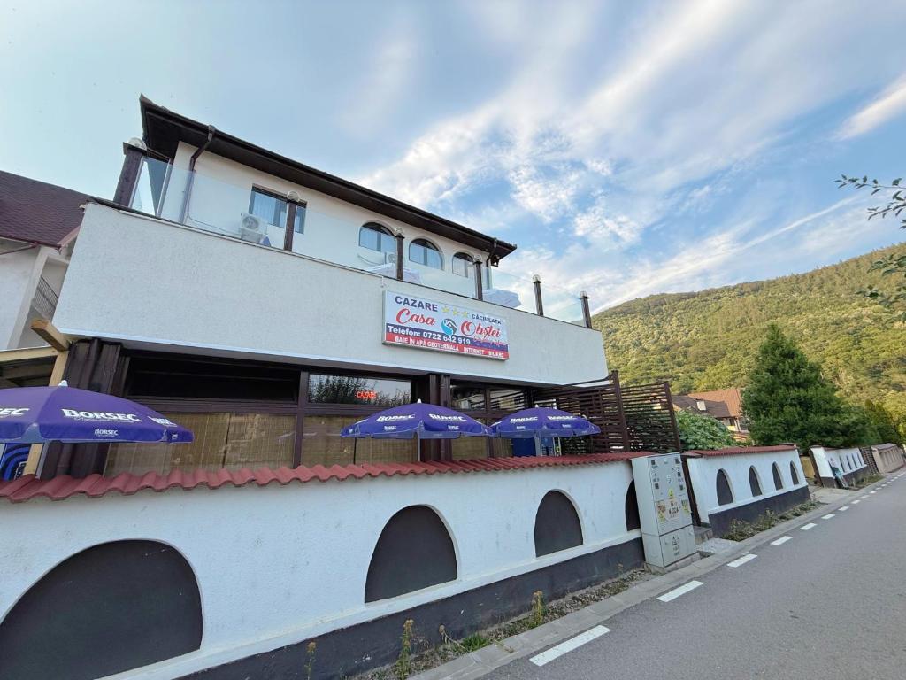 a building with umbrellas on the side of a road at Casa Obstei Caciulata in Caciulata