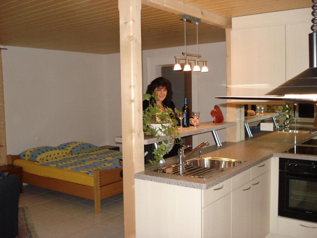 una mujer parada en una cocina con fregadero en Haus am See II, en Därligen