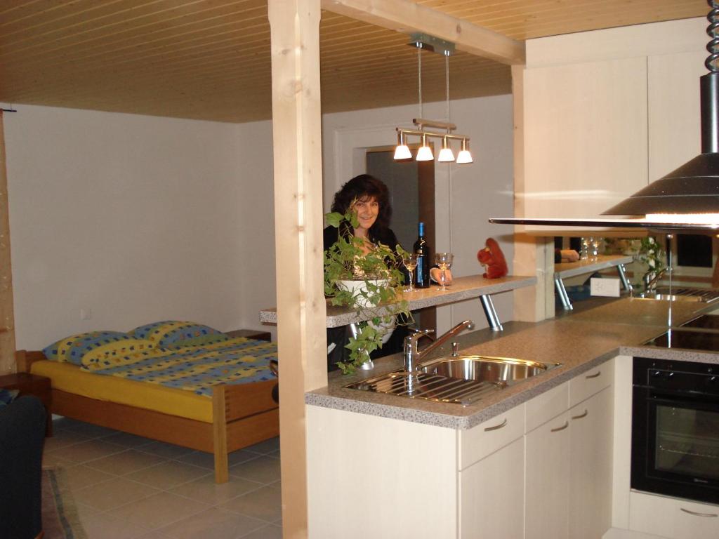 a woman standing in a kitchen with a sink at Haus am See II in Därligen