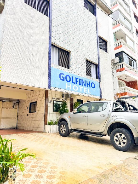 a car parked in front of a hotel at Golfinho Hotel in São Vicente