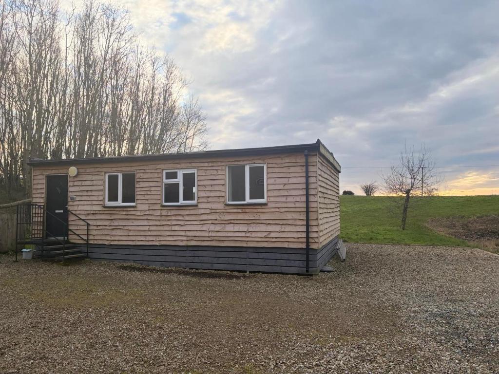 a tiny house sitting on top of a gravel lot at John D's Cabin Getaway in Derry Londonderry