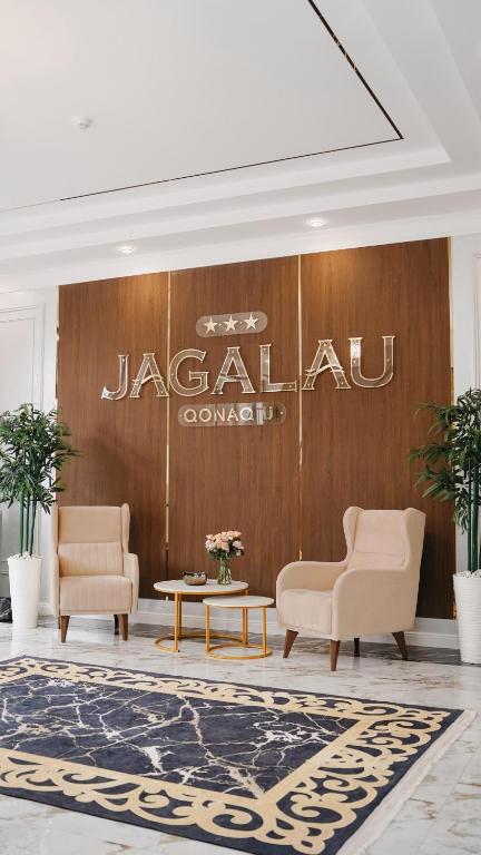 a lobby with two chairs and a table and a sign at Jagalau in Balqash