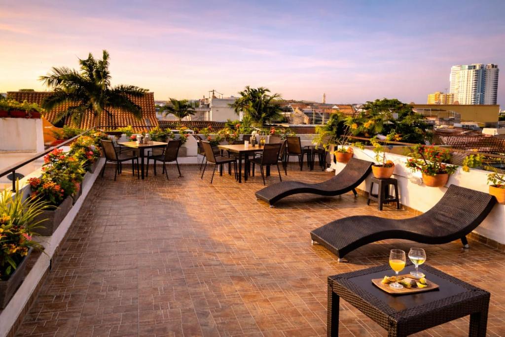 a patio with tables and chairs on a roof at Maloka Boutique Centro Histórico in Cartagena de Indias