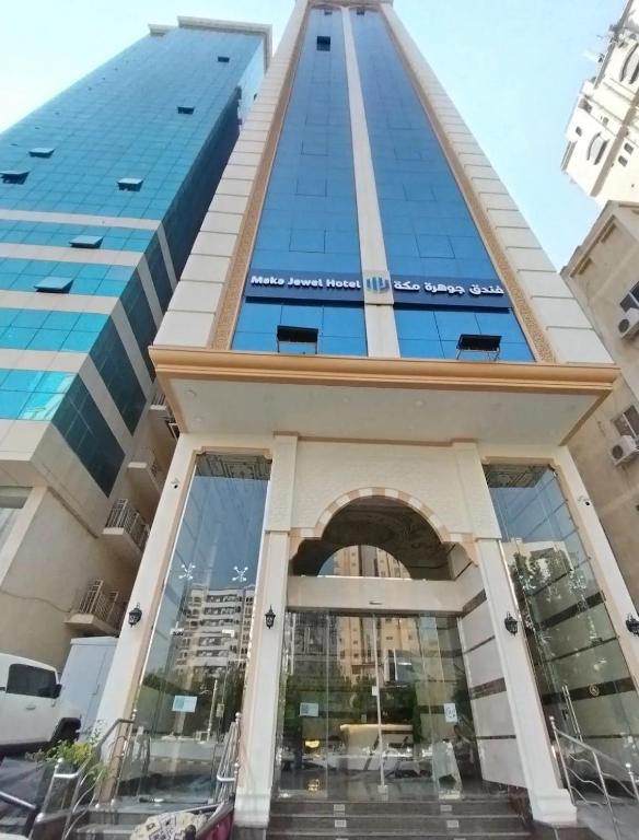 a tall building with a glass facade at جوهرة مكة الفندقية in An Naqāʼ