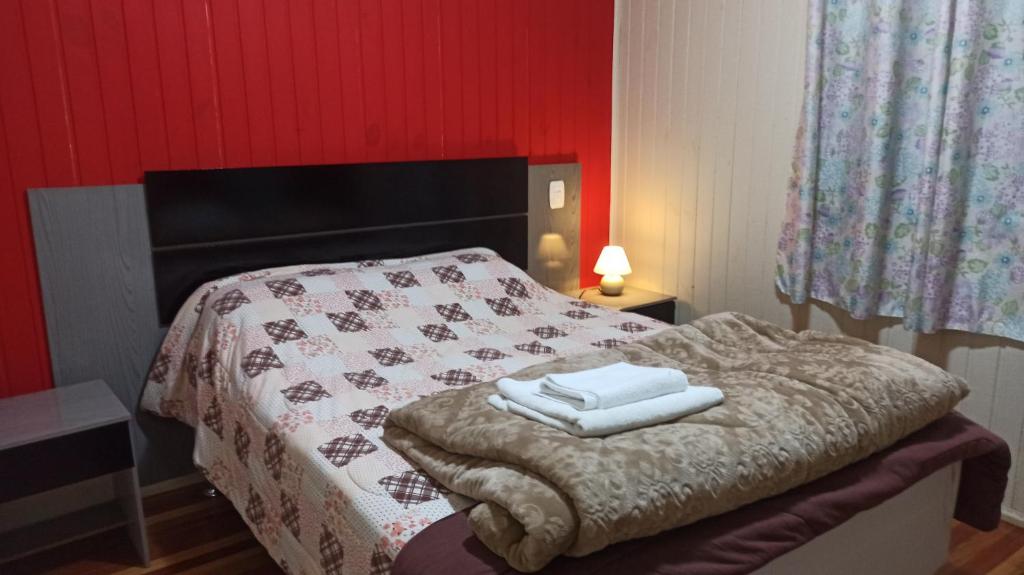 a bedroom with a bed with two towels on it at Chalé Paraíso Da Serra 01 in Gramado