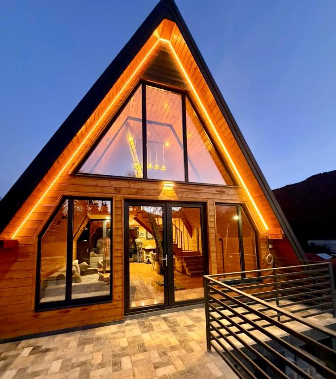 a house with large glass windows and a roof at Twin Cabins Azuga in Azuga