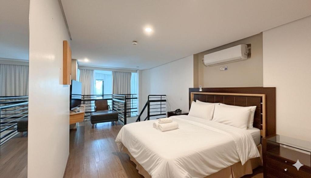 a bedroom with a bed and a living room at Duplex com Banheira no Centro de Campo Grande in Campo Grande