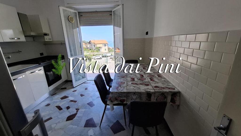 a kitchen with a table and chairs and a window at Vista dai pini in Varazze