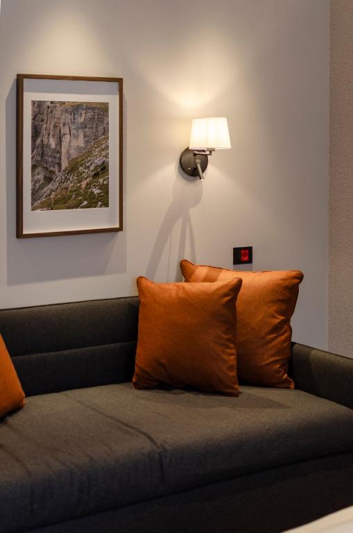 a couch with orange pillows in a room at Dolomiten Apartments in Tesero