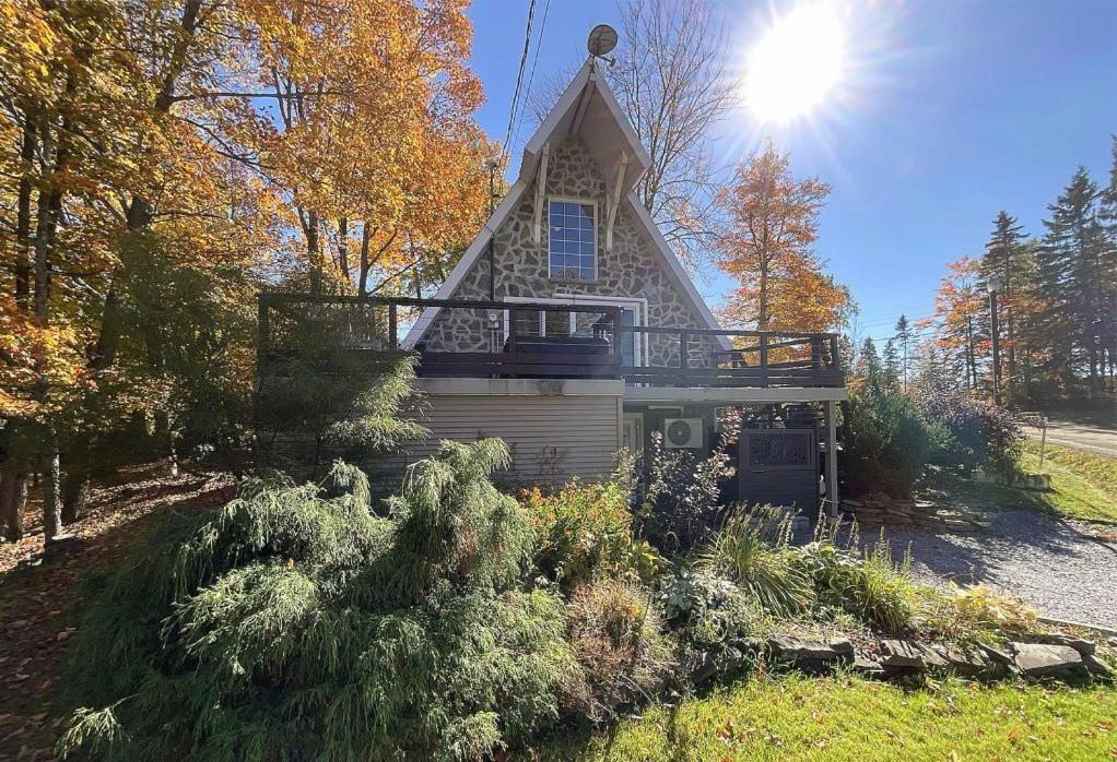 a house with a balcony on the side of it at Chalet Spa - La Détente au Mont-Comi in Saint-Gabriel