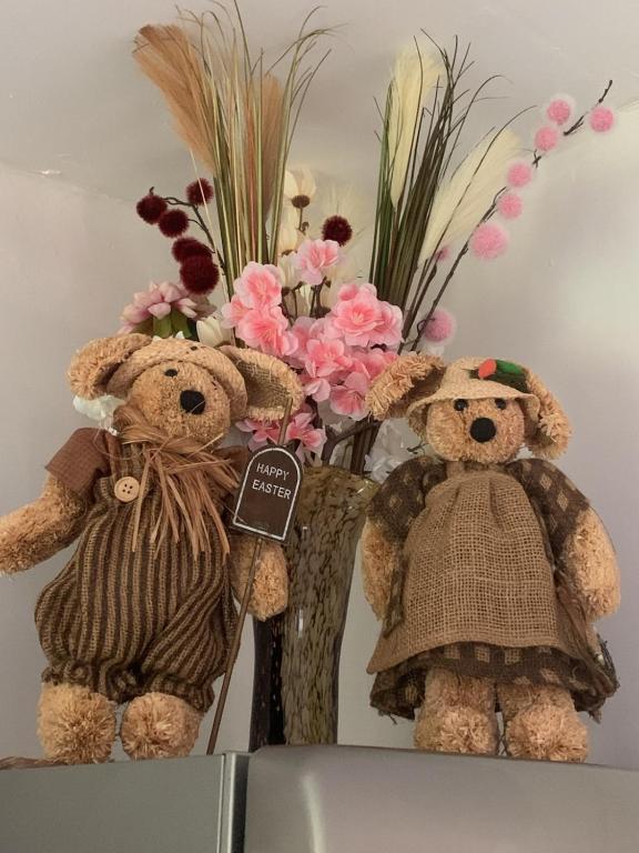 two teddy bears sitting next to a bouquet of flowers at Le rêve chrysalide in Masseret