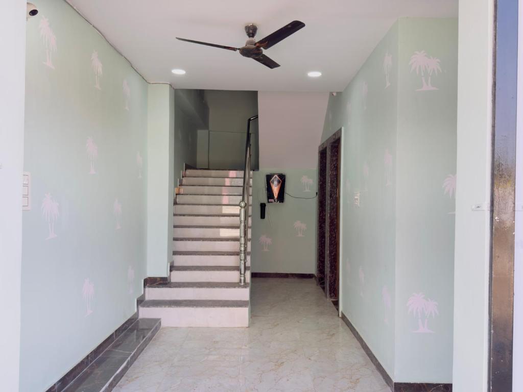 a stairway with a ceiling fan and a staircase at Hotel Paradise in Rewa