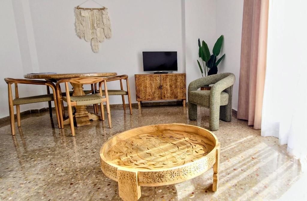 a living room with a table and chairs and a table and a couch at Mirador la Jardinera- céntrico con parking privado GRATIS in Teruel