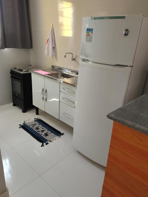 a kitchen with a white refrigerator and a stove at Aconchego da Alegria!!! in Porto Seguro