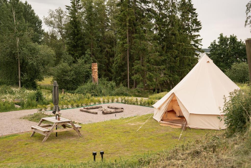 a tent and a picnic table in a field at Ulvsby Ranch Glamping in Karlstad