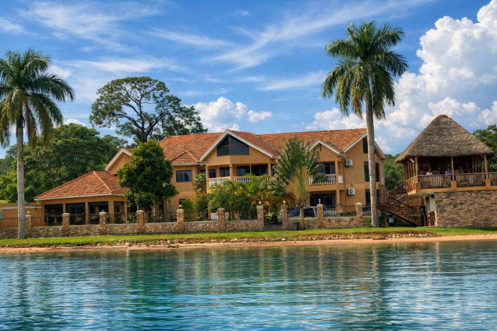 a house on the water with palm trees at Sienna Beach Hotel - Entebbe in Entebbe