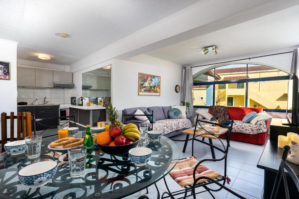 a living room with a table with fruit on it at Blue Bay Apartment in Gouvia