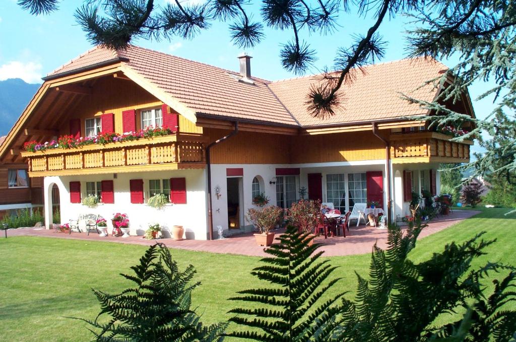 ein Haus mit einem Balkon und einem Tisch in der Unterkunft Haus Abendberg in Wilderswil