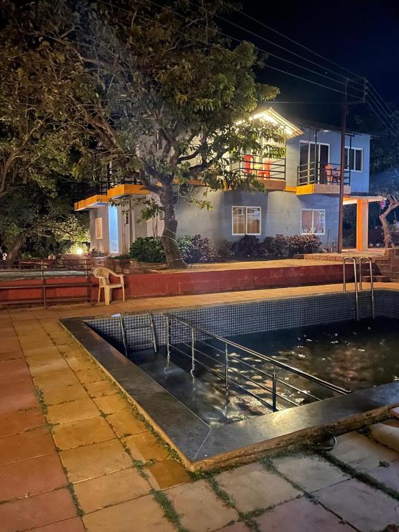 a swimming pool in front of a house at night at Mist Leaf Villa Mahabaleshwar in Mahabaleshwar