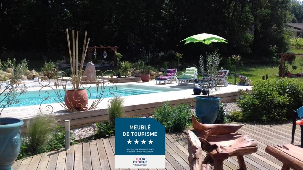 a garden with a pool and a sign that says welcome to the house at Les ptits bonheurs, maison proche de St-Emilion in Frontenac